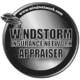 A silver and black round logo for windstorm